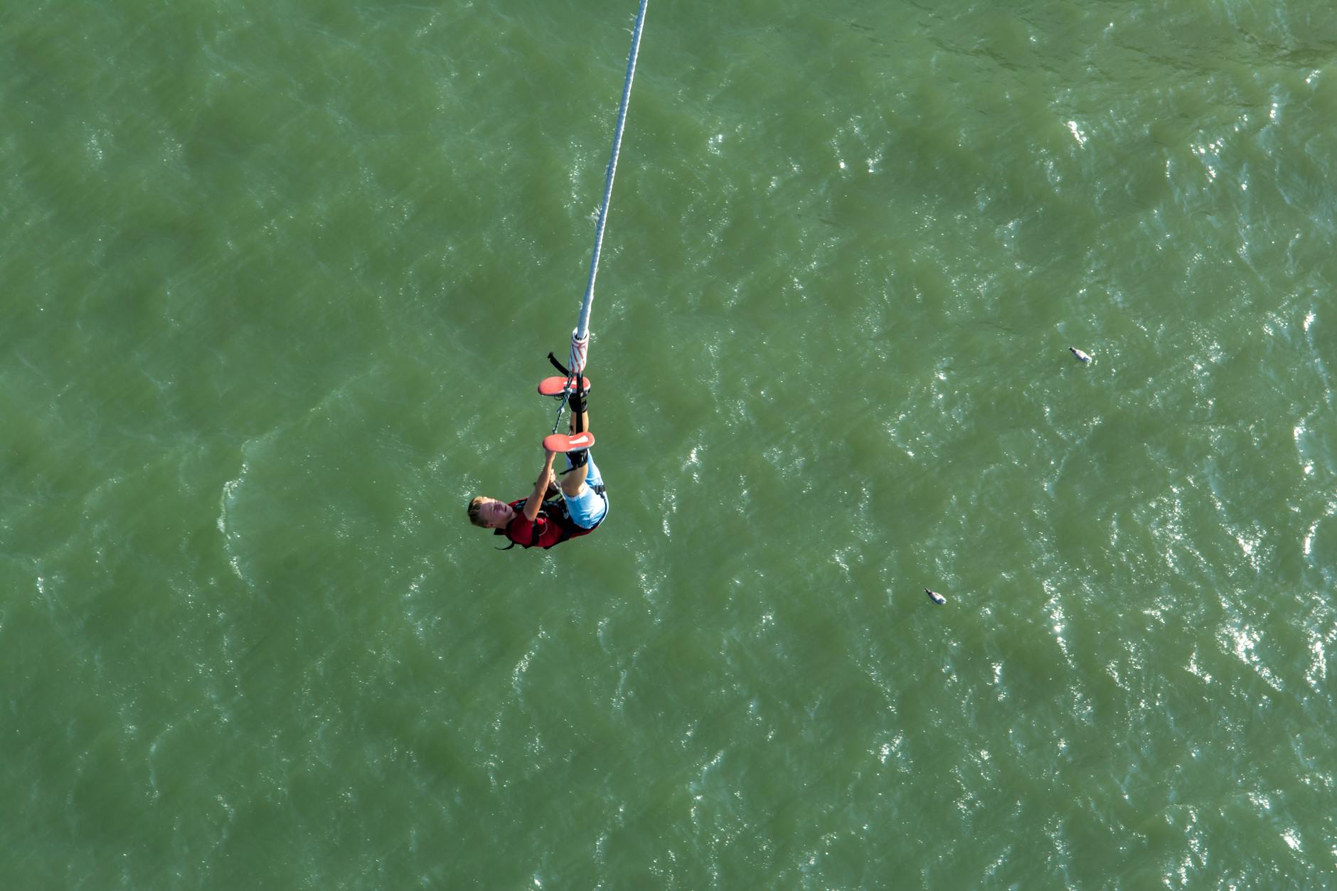 Bungy jumper leaping from a high cliff with river below