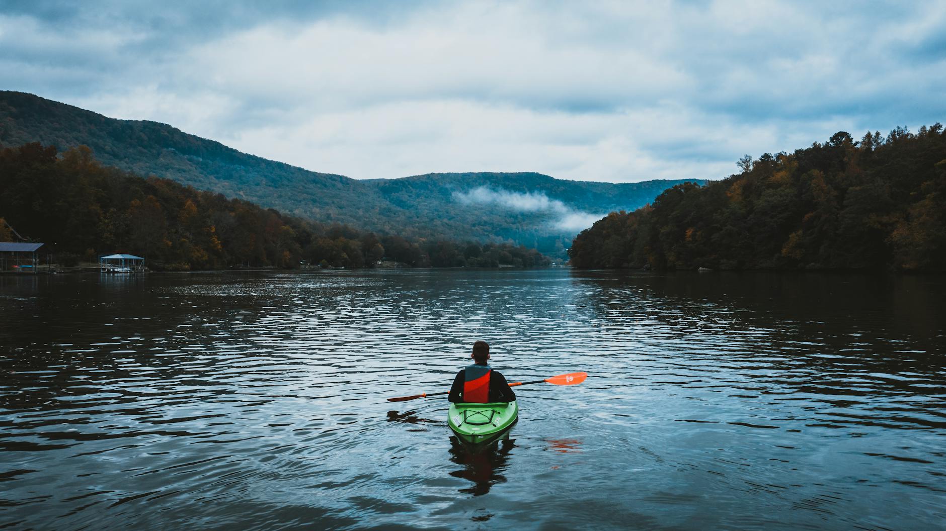 Kayakers paddling on calm lake waters surrounded by mountains