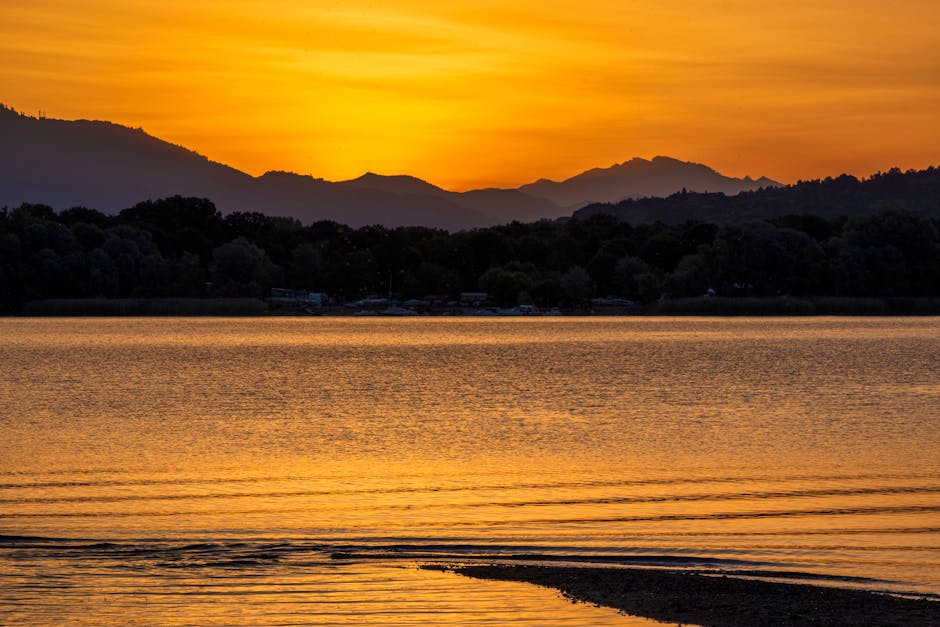 Peaceful sunset over a calm lake with mountain reflections