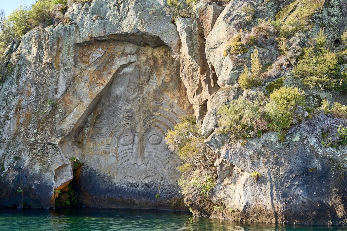 Maori Rock Carvings at Mine Bay on Lake Taupo New Zealand carved into cliff face