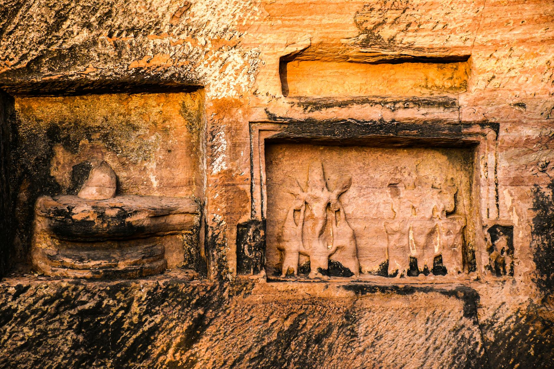 Ancient rock carvings carved into cliff face above lake waters