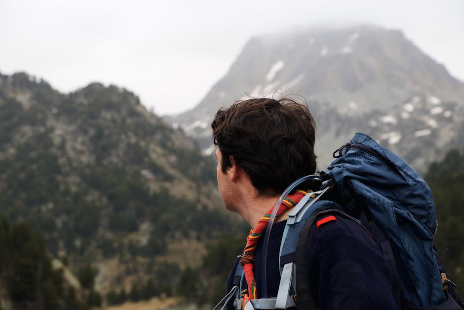 Solo backpacker standing on a mountain trail enjoying the view