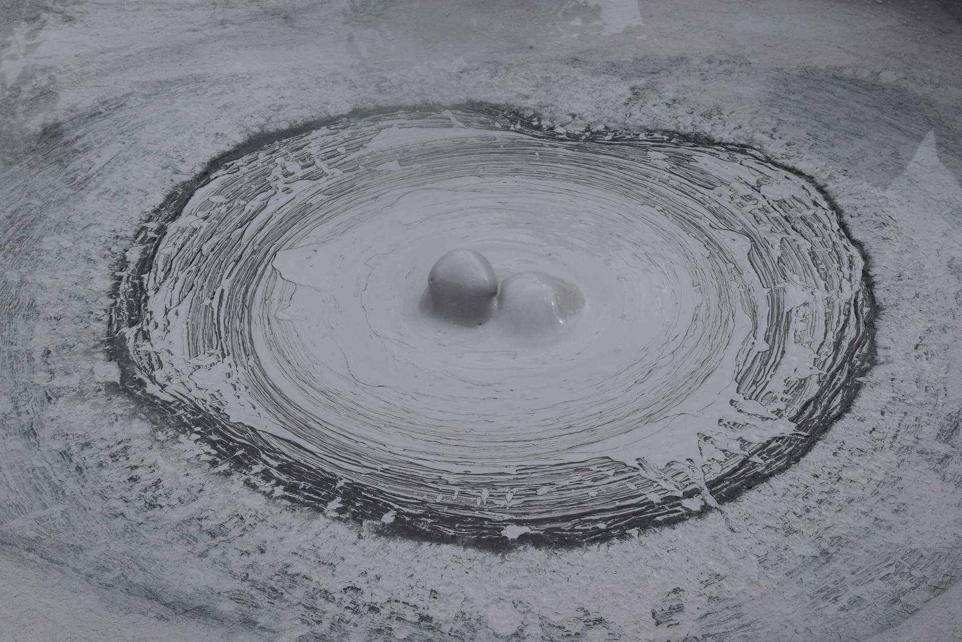 Bubbling geothermal mud pool with steam in New Zealand volcanic area