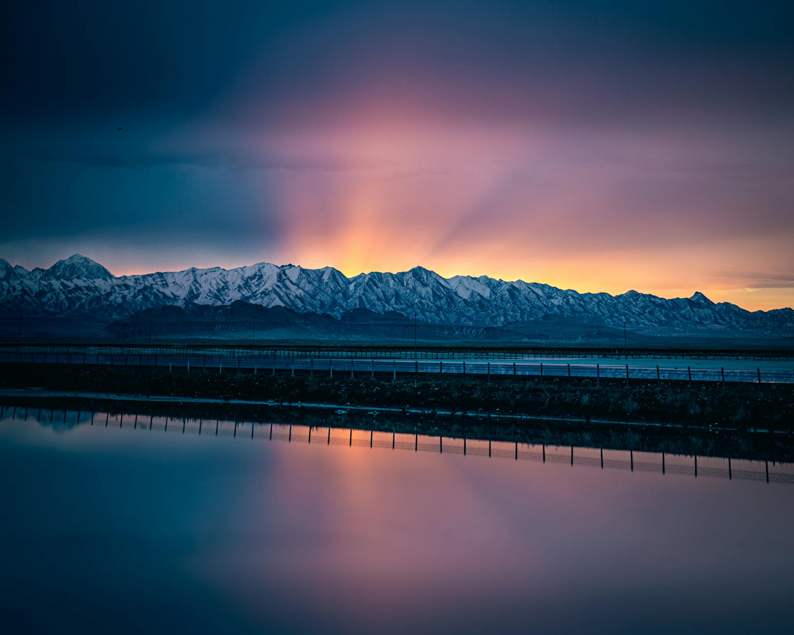 Scenic sunrise over a calm lake with mountain reflections like Lake Taupo