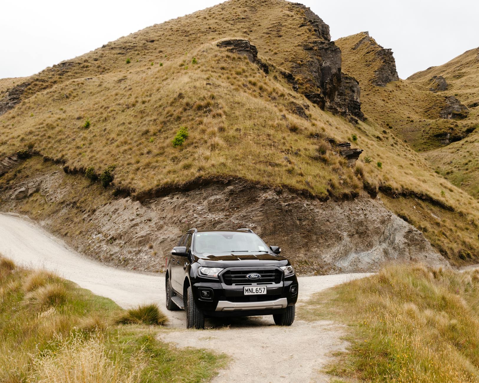 Vehicle parked at a scenic trailhead with safety precautions for backpackers in New Zealand