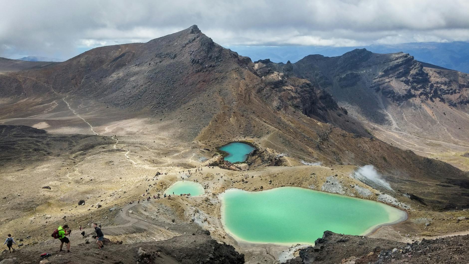 Hikers crossing the Tongariro Alpine Crossing volcanic landscape