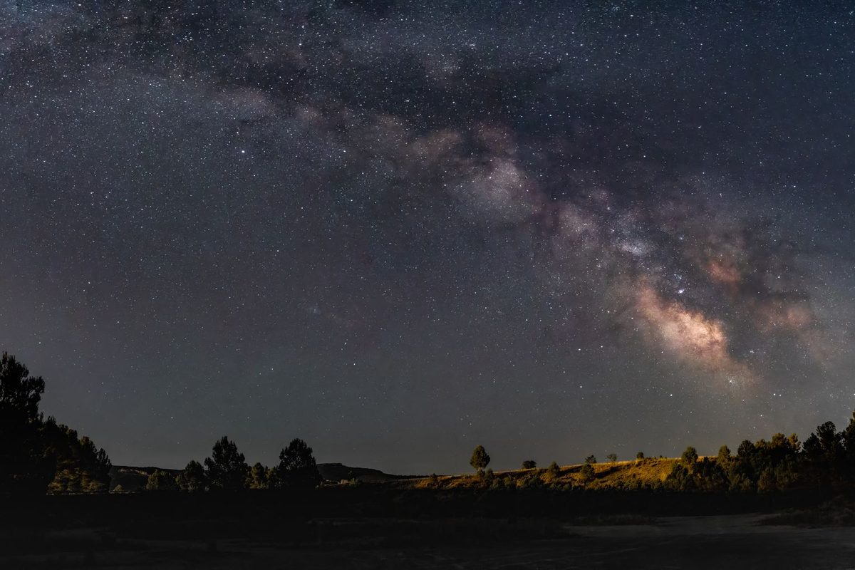 Stars and the Milky Way over a dark horizon