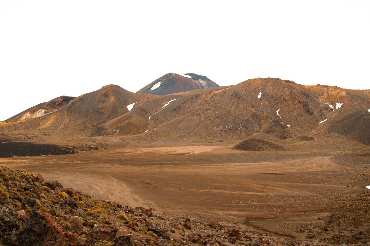 Volcanic desert terrain and distant peaks in Tongariro National Park