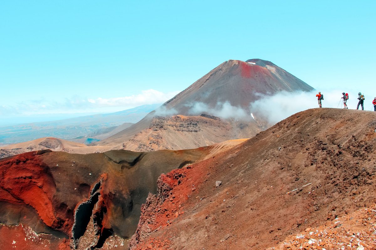 Trampers with full packs pausing near Red Crater with Ngauruhoe behind, Tongariro National Park
