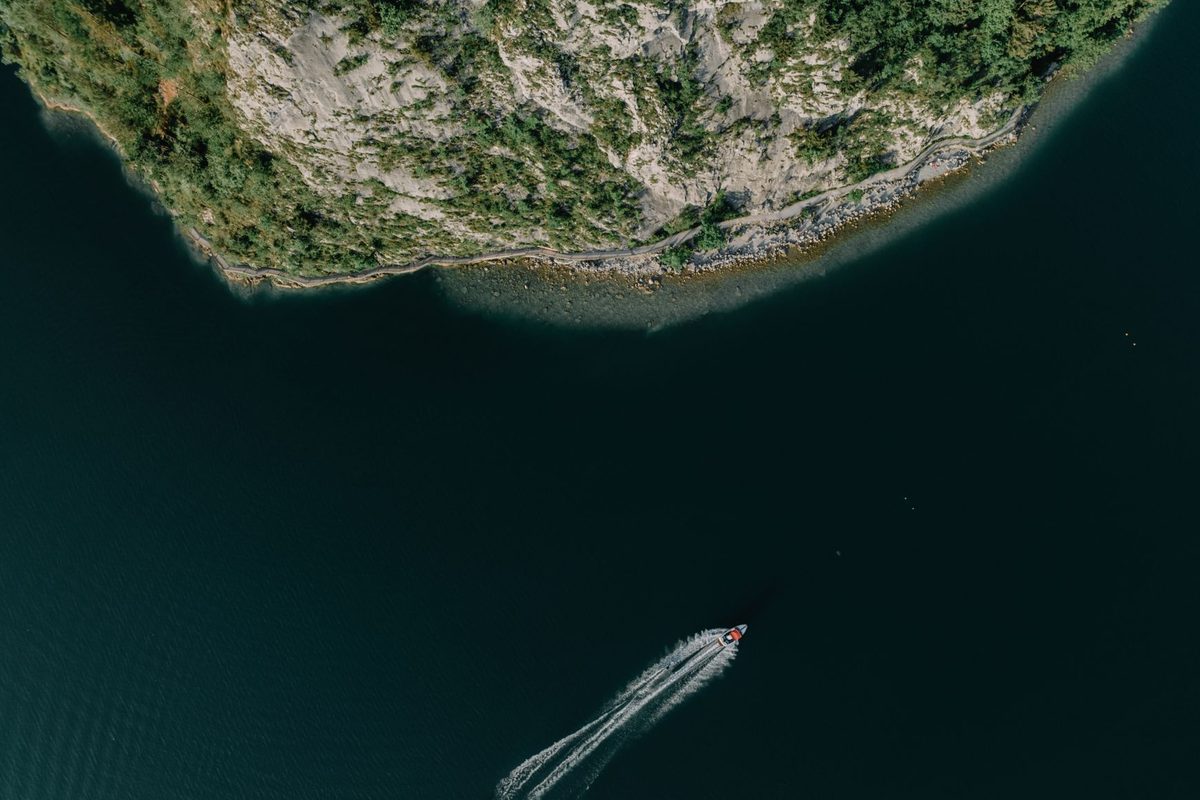 A small boat crossing deep open water from above